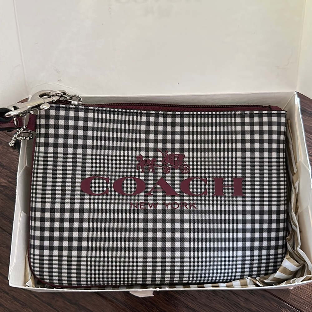 Small coach wristlet with black, white, and deep neutral plum accents